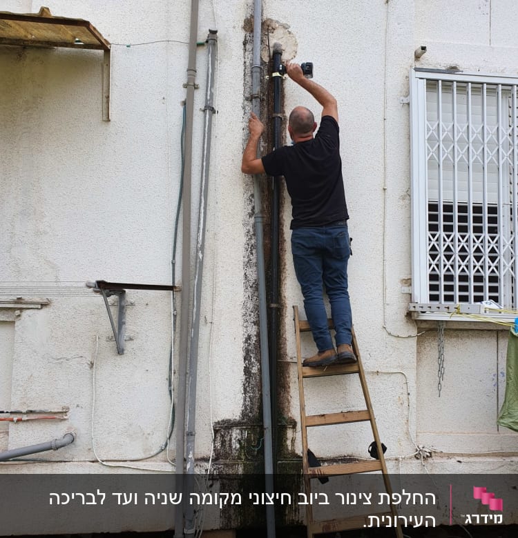 אדם על סולם מתקן צינור חיצוני עם כלי עבודה